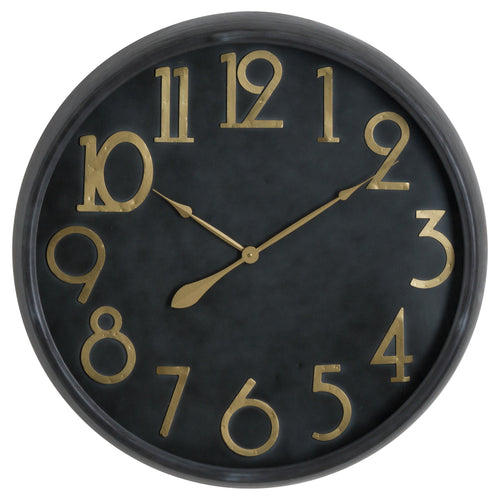 A wall clock with a black face and gold brass numerals and hands.