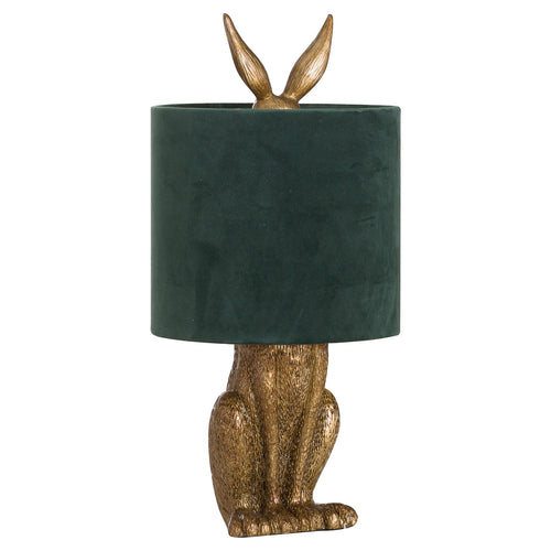 An antique gold table lamp in the shape of a hare with a green velvet shade.