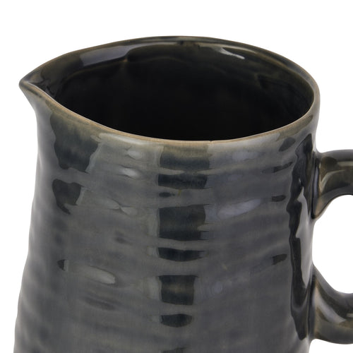 Black ceramic pitcher with textured surface on a white background