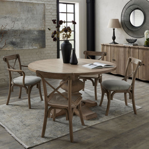 Dining room with wooden table and chairs on a rug, decorative elements on the wall and sideboard.