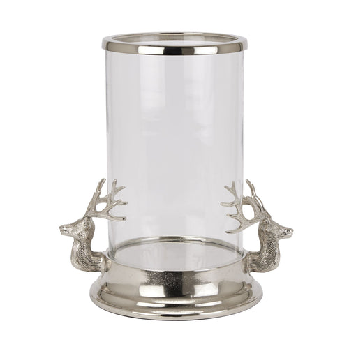 A clear glass hurricane lantern with silver stag heads on the sides and a silver base.