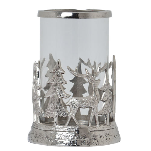 A silver-colored metal hurricane lantern with a scene of stags and pines, designed to be illuminated for ambiance.