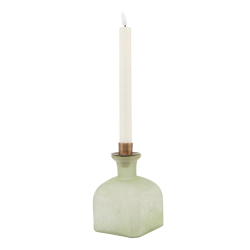 A Smoked Sage and Aged Brass Candle Holder Vase with a white candle, displaying a green tinted glass vase with a bronze colored metal holder at the top.