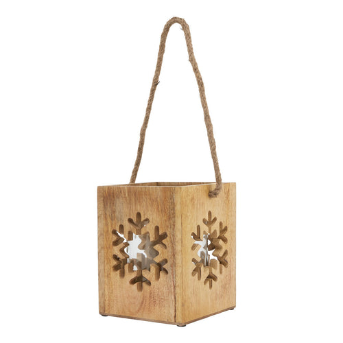 A beige wooden candle holder with a large snowflake pattern cut out, suspended by a rope.