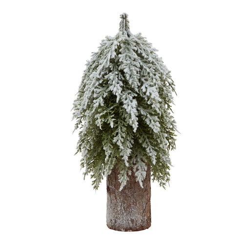 A small artificial fir tree dusted with snow, placed on a tall wooden log.