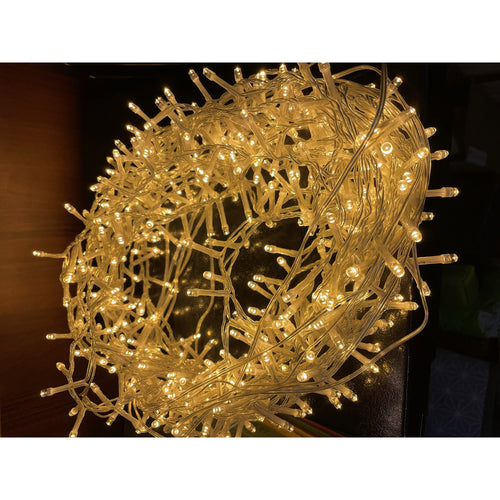 A coil of silver-toned wiring with an LED light strand radiating a warm white glow.