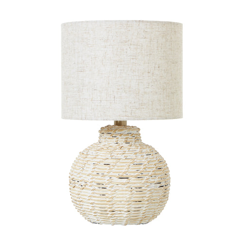 A small bulbous wicker table lamp with a beige linen shade, displaying a warm white washed color.