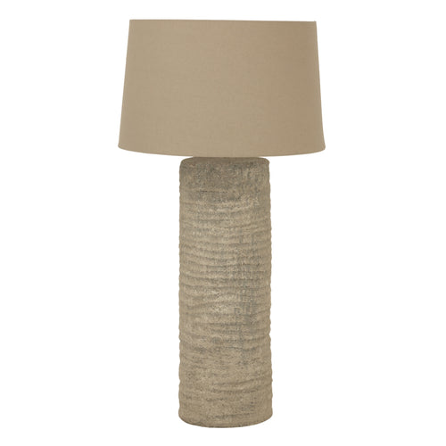 A tall Tuscan grey lamp with a beige lampshade on a white background.
