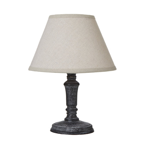 A Palmyra Column table lamp with a linen shade on a distressed black base.