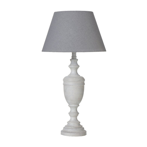 A table lamp with a white urn-shaped base and a grey linen shade.