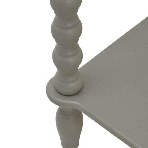 Leg of a  gray two-drawer console table with spindle legs and a lower shelf.