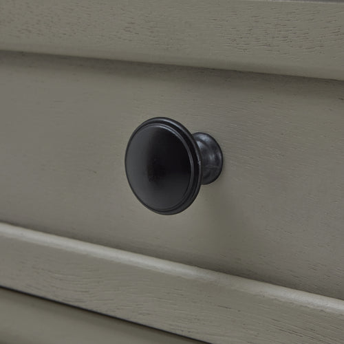 Close up of drawer Knob of a  gray two-drawer console table with spindle legs and a lower shelf.