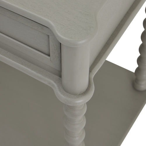 Corner with leg i view of a gray console table with two drawers and a lower shelf, featuring a sleek design with spindle legs.