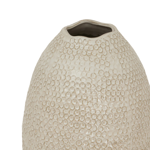 T beige ceramic vase with an oval shape and a textured surface.p of a 