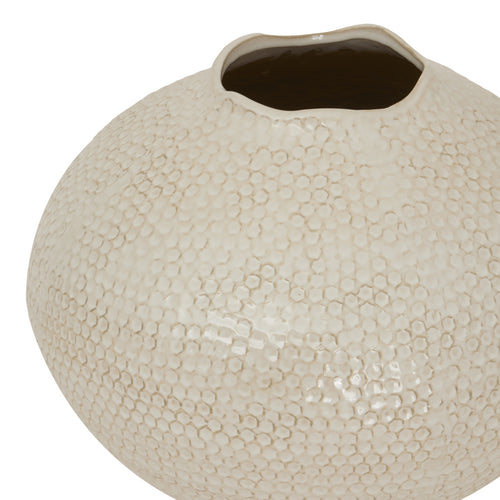 Top of a  beige caldron-shaped ceramic vase with a mottled surface and a visible textured exterior.