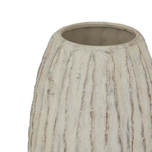 Top of a beige ceramic vase with a geometric pattern and a ribbed texture, standing on a flat surface.