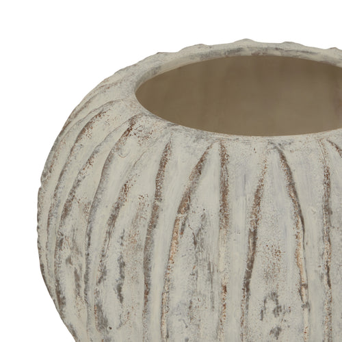 A top view of a beige round vase with a sculpted fin texture