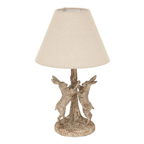 Decorative table lamp with beige shade and metal base on a white background