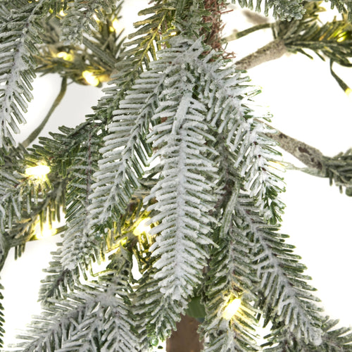 Frosty artificial Christmas tree branch with lights on a white background