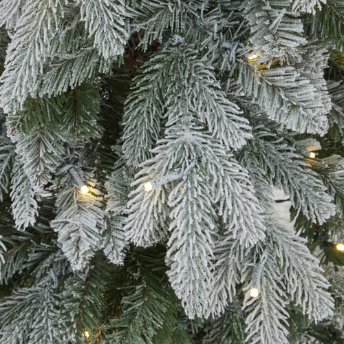 Close-up of a frosted artificial Christmas tree with lights.