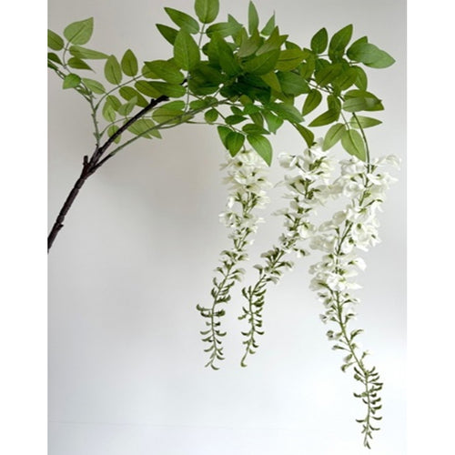 Artificial green leaves and white flowers on a plain background