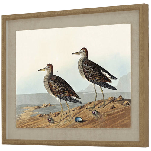 A framed artwork featuring two sandpipers on a natural linen background with a beaded frame.