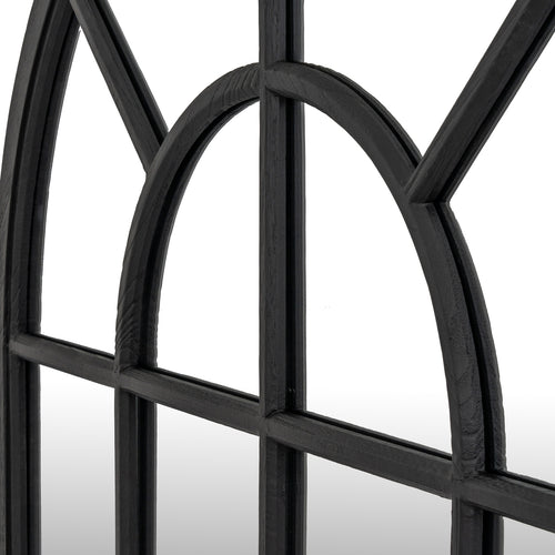 Close-up of a black metal window frame with arched design on a white background