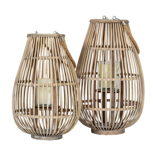 Two woven rattan lanterns with candles inside on a white background