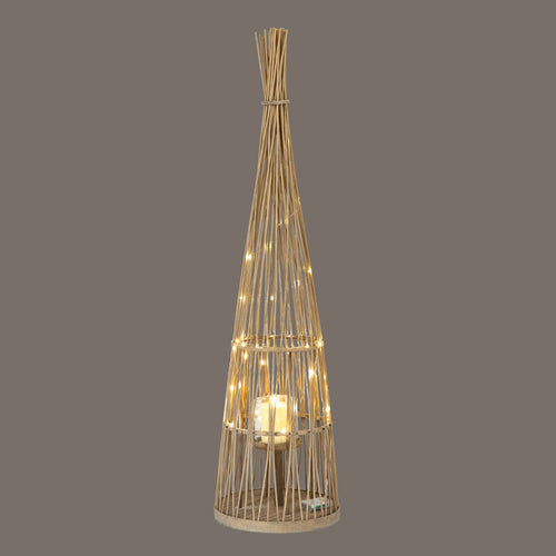 Woven rattan floor lamp with a warm glow on a dark background