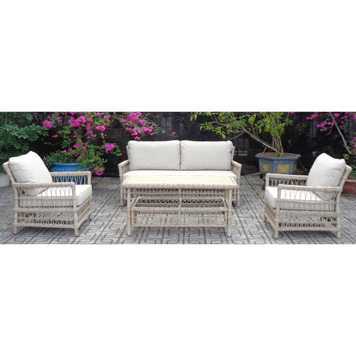 White wicker outdoor furniture set with cushions on a patio