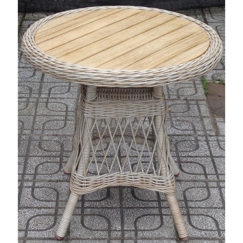 Round wicker table with wooden top on a patterned pavement