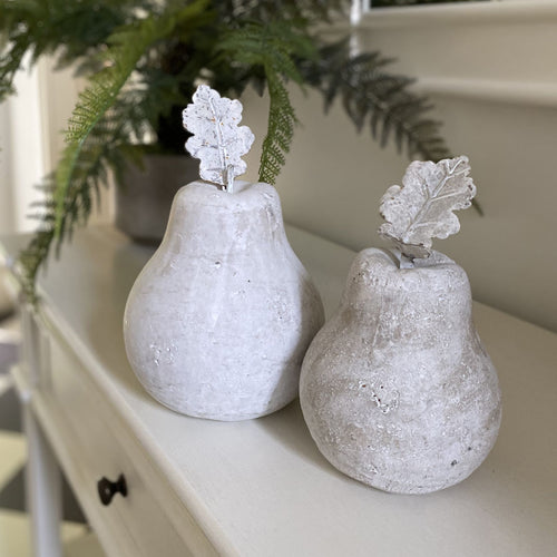 Two pear-shaped decorative vases with leaf accents on a white surface.