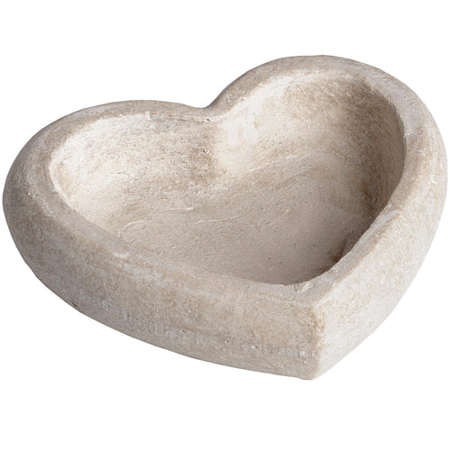 A heart-shaped, beige stone dish with a rustic finish.